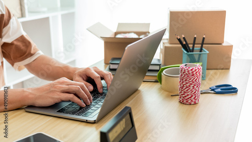 Online shopping concept an online seller typing on his laptop to fill the customer data