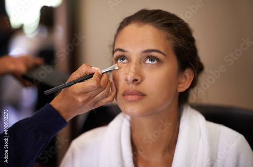 Makeover time. Shot of an attractive young woman having makeup applied to her face.