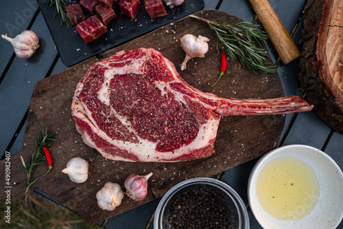 Sliced grilled thai steak served on white plate with grilled sliced lemon, tomatoes, garlic