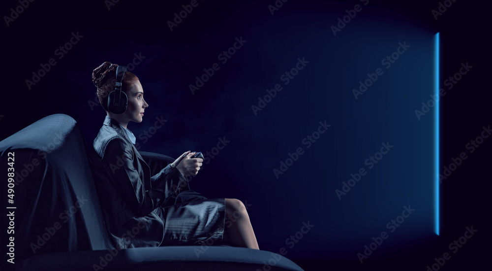 A woman in headphones with a controller set aside in her hands A woman in headphones with a controller set aside in her hands