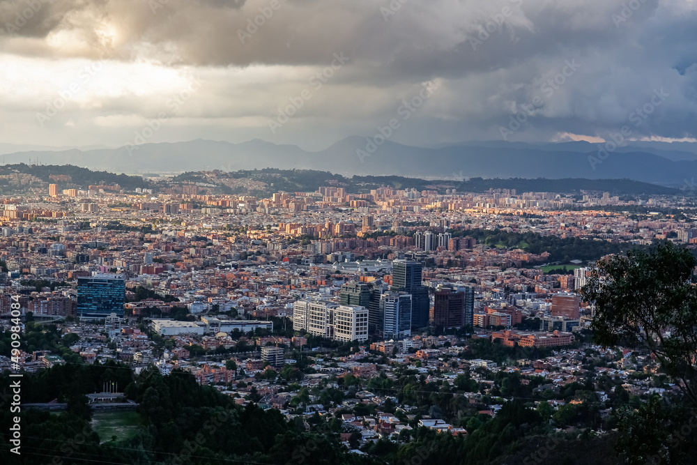 Panoramic view over the high plateau with the Colombian capital Bogota with dramatic cloudy sky and sunlight
