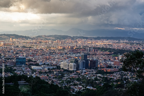 Panoramic view over the high plateau with the Colombian capital Bogota with dramatic cloudy sky and sunlight 