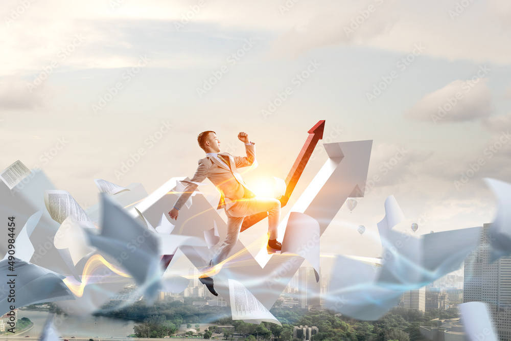 Fototapeta premium Portrait of energetic businessman jumping in open air