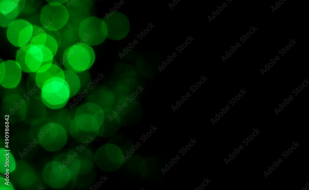 Obraz premium Abstract blur image of green light of beautiful bokeh on black background with copy space. Blurred festive, night party and celebration bokeh background.
