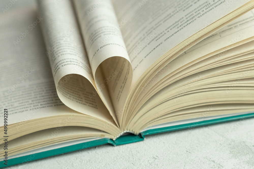 Fototapeta premium an open book with folded pages in the shape of a heart 