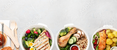 Healthy meal prep in lunch boxes on light background.