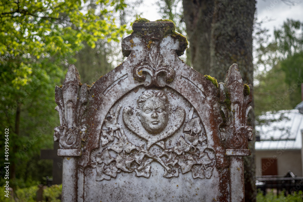 fragment of old vintage white marble tombstone with angel bas relief. Latvia cemetery, Lielvircava graveyard

