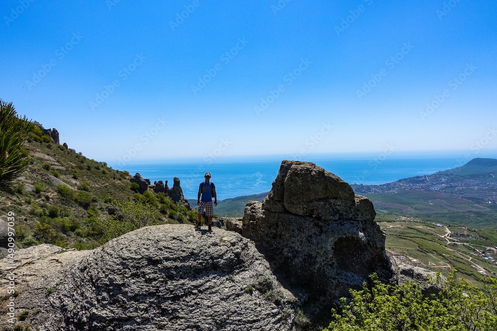 A man on the background of the plateau of the Crimean mountains and the Black Sea from the top of Demerji. Russia.