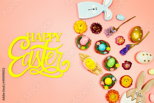 Coloeful easter eggs in nest on pink color background with space. Minimal concept. Card with copy space for text. photo