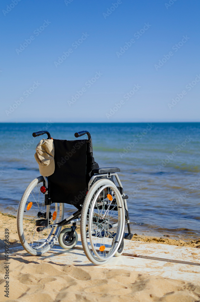 Fototapeta premium wheelchair on the seashore. disabled person resting on the sea