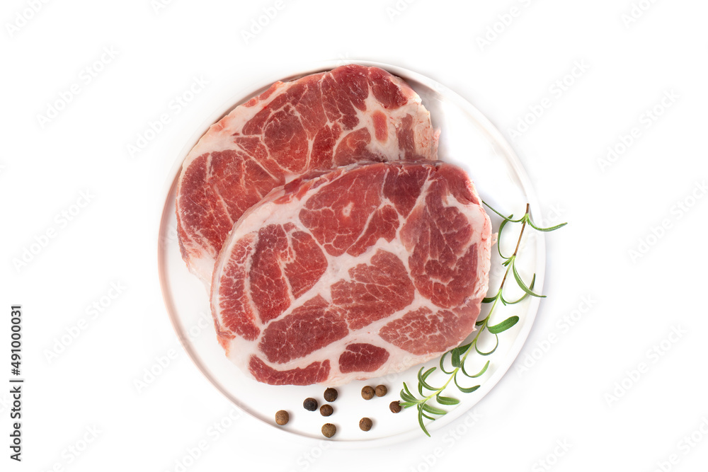 Pieces of marbled steak of raw pork or beef with a sprig of rosemary and pepper peas on a white plate on a white background. Pieces of marbled steak of raw pork or beef with a sprig of rosemary and pepper peas on a white plate on a white background.