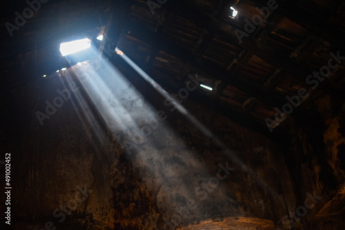 sun rays enter through the broken roof in house.
