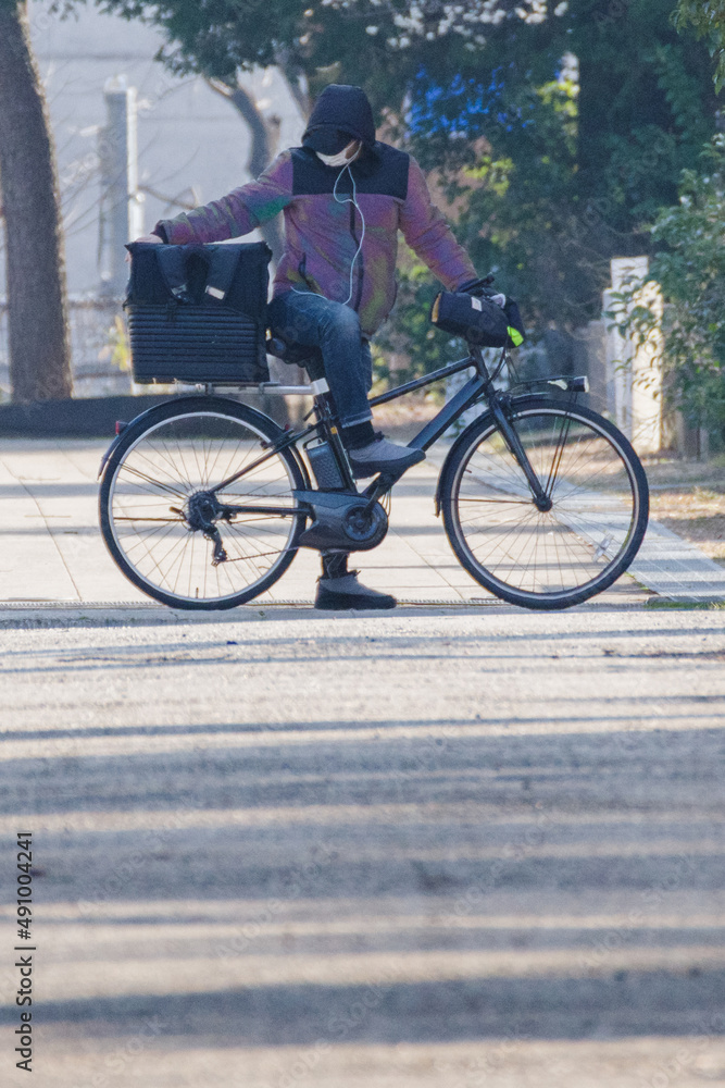 Fototapeta premium 自転車でフードデリバリーをする東京港区南青山2丁目の青山霊園での風景
