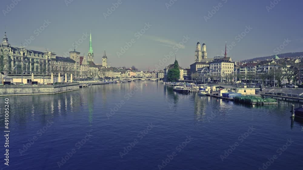 Panoramic view of City of Zürich with river Limmat and cityscape of the medieval old town on a sunny spring day. Movie shot March 3rd, 2022, Zurich, Switzerland.