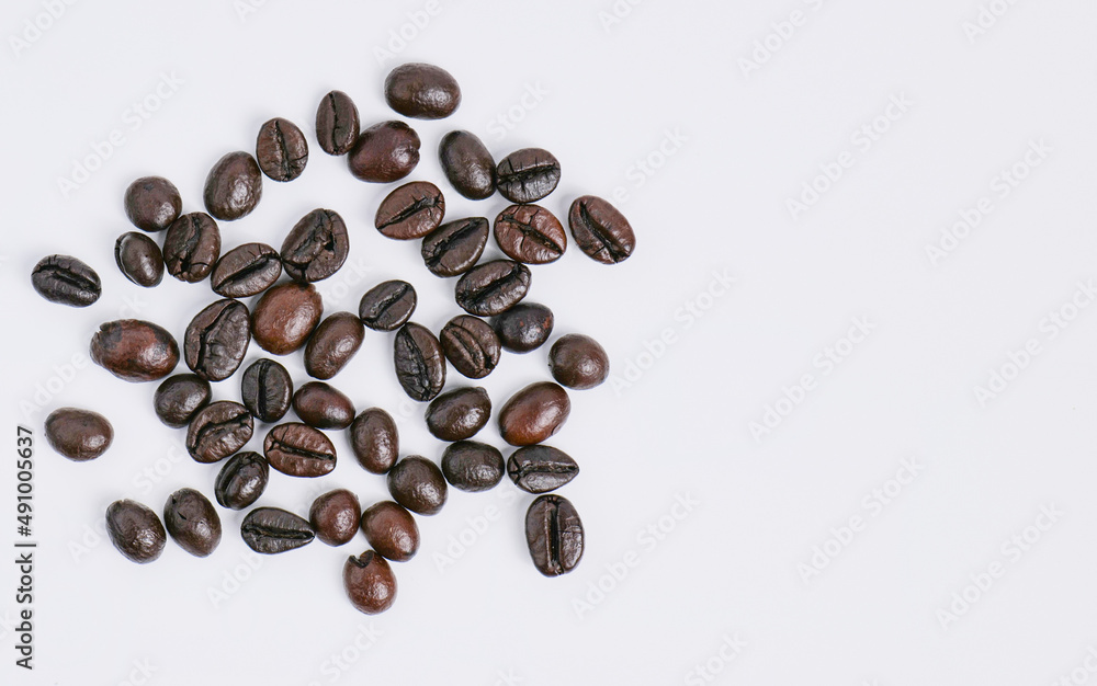 Naklejka premium Roasted coffee beans with shiny skin It has been carefully selected. Ready to grind and bring to the brew Taken from a high angle with the aroma of coffee. on a white background in the studio