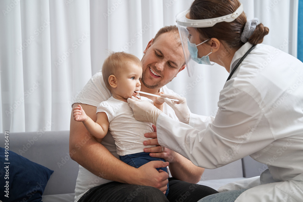Doctor using tongue depressor to check baby throat Doctor using tongue depressor to check baby throat