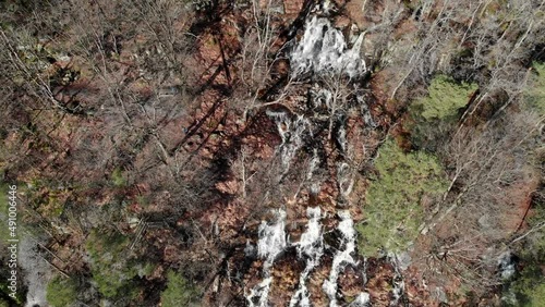 Close-up Aerial view and establishing shot of Ramhultafallet waterfall with water flowing through forest flowing lake Lygnern near Göteborg (Gothenburg), Sweden - Sätila-Marks, Västra Götaland Region photo