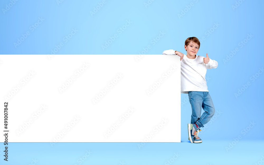 A kid show thumb up near mockup poster on bright background A kid show thumb up near mockup poster on bright background