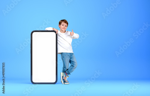 Bild auf Leinwand A kid thumb up near phone mockup display on bright background