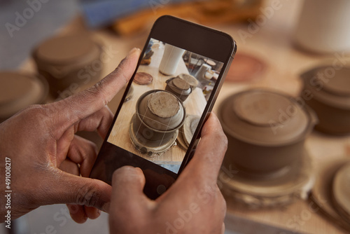 Ceramist photographing his earthenware products in pottery studio