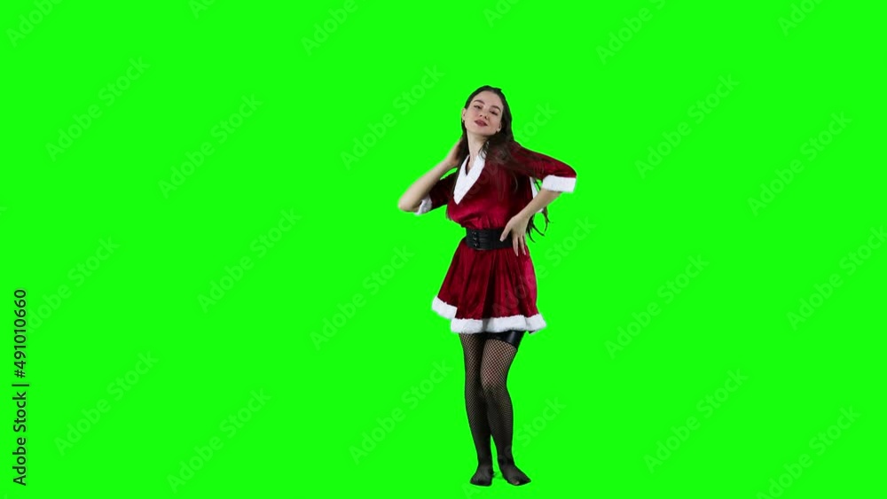 Beautiful lady dancing in front of the green screen in Christmas costume Beautiful lady dancing in front of the green screen in Christmas costume