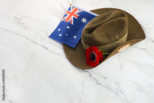 Foto Anzac army slouch hat with Australian Flag and Poppy on stone background