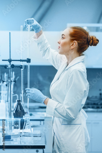 Professional female scientist is working on a vaccine in a scientific research laboratory. Genetic engineer workplace. Technology and science concept. Stop COVID-19