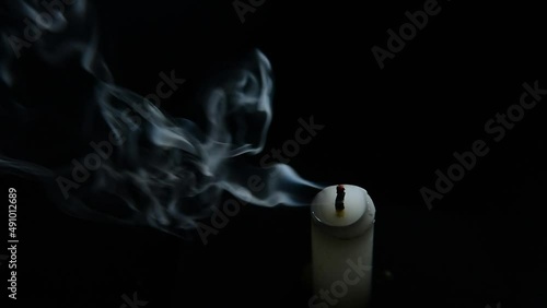candle light blow off by the wind smoke on black background