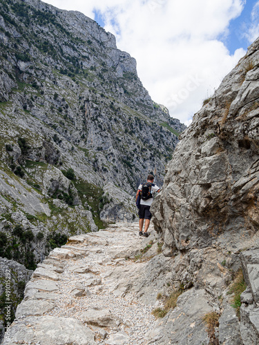 Senderista desconocido caminando en la Ruta del Cares desde Poncebos en Asturias, para senderistas amantes de la naturaleza y excursiones de montaña, en el verano de 2020