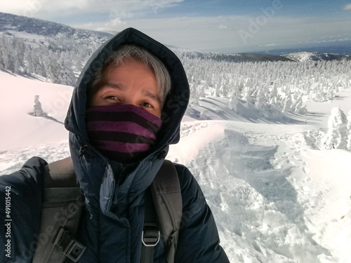 Young Man Smile Camera Taking Selfie Photo on top viewpoint mountain Zao, Yamagata. with snow monster background.
