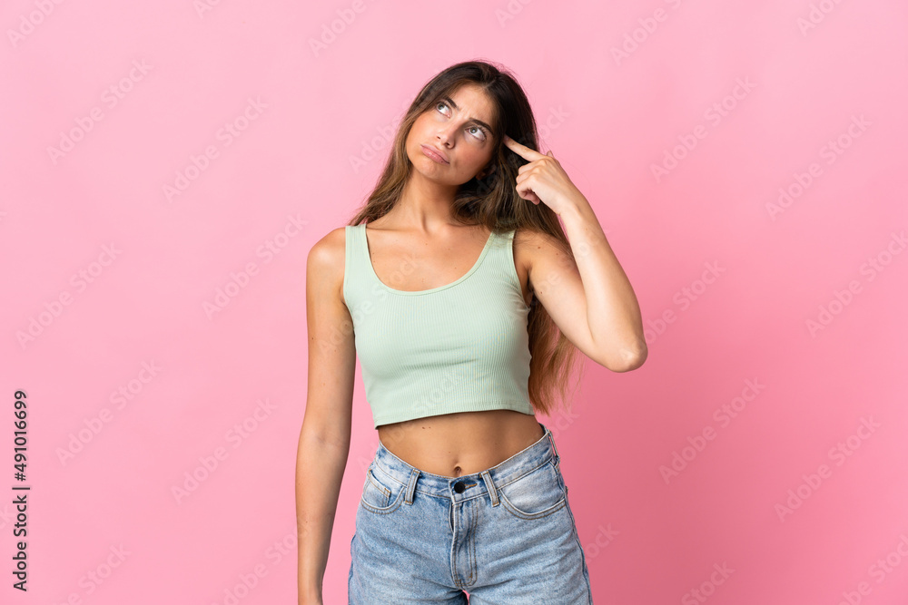 Young caucasian woman isolated on pink background making the gesture of madness putting finger on the head Young caucasian woman isolated on pink background making the gesture of madness putting finger on the head