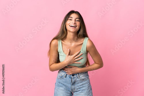 Young caucasian woman isolated on pink background smiling a lot © luismolinero