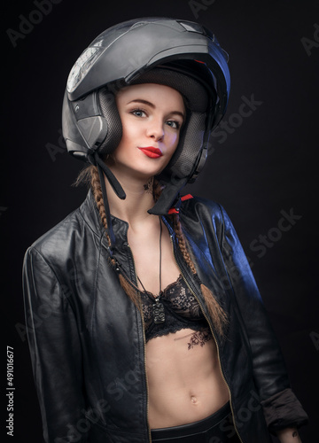 A young girl in a helmet poses in the studio. © SergeiPh