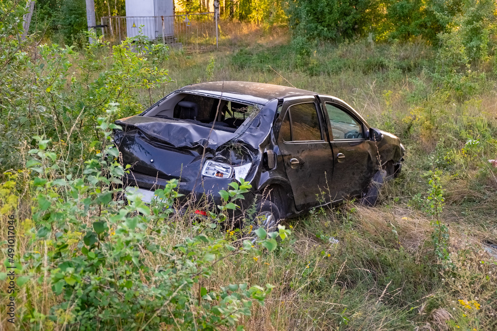 A car wrecked after an accident on the side of the road A car wrecked after an accident on the side of the road