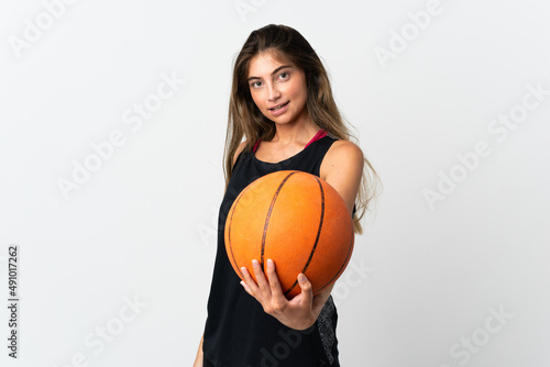 Young caucasian woman isolated on white background playing basketball © luismolinero