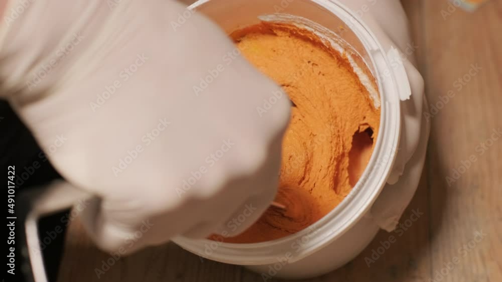 A worker kneads the paint for painting the walls A worker kneads the paint for painting the walls