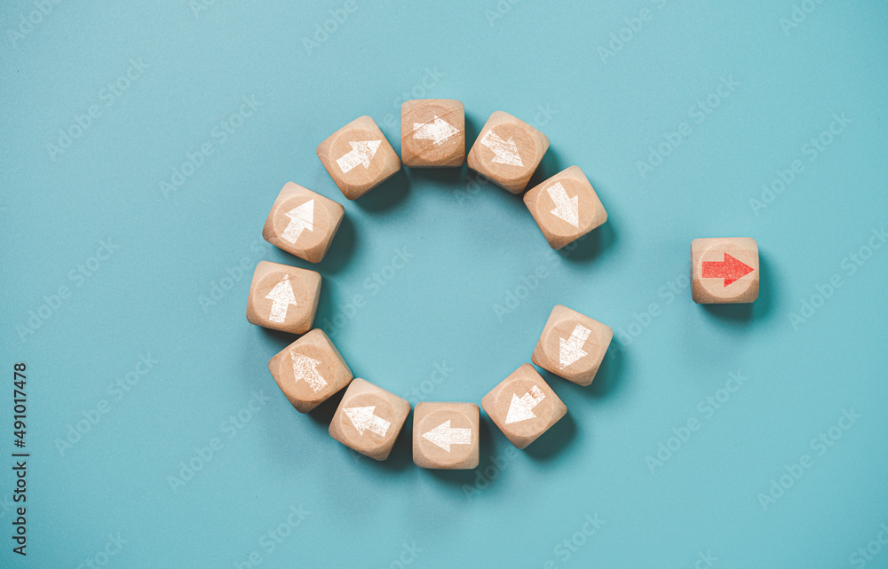 Disruption and technology transformation concept , Red arrow on wooden block cube move out from circle white arrow on blue background. Disruption and technology transformation concept , Red arrow on wooden block cube move out from circle white arrow on blue background.