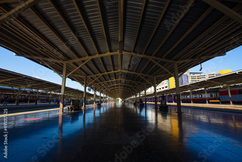 Perspective railway station platform under a steel frame roof