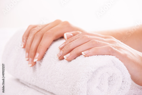 Manicured nails. Cropped shot of a womans hands resting on a towel.