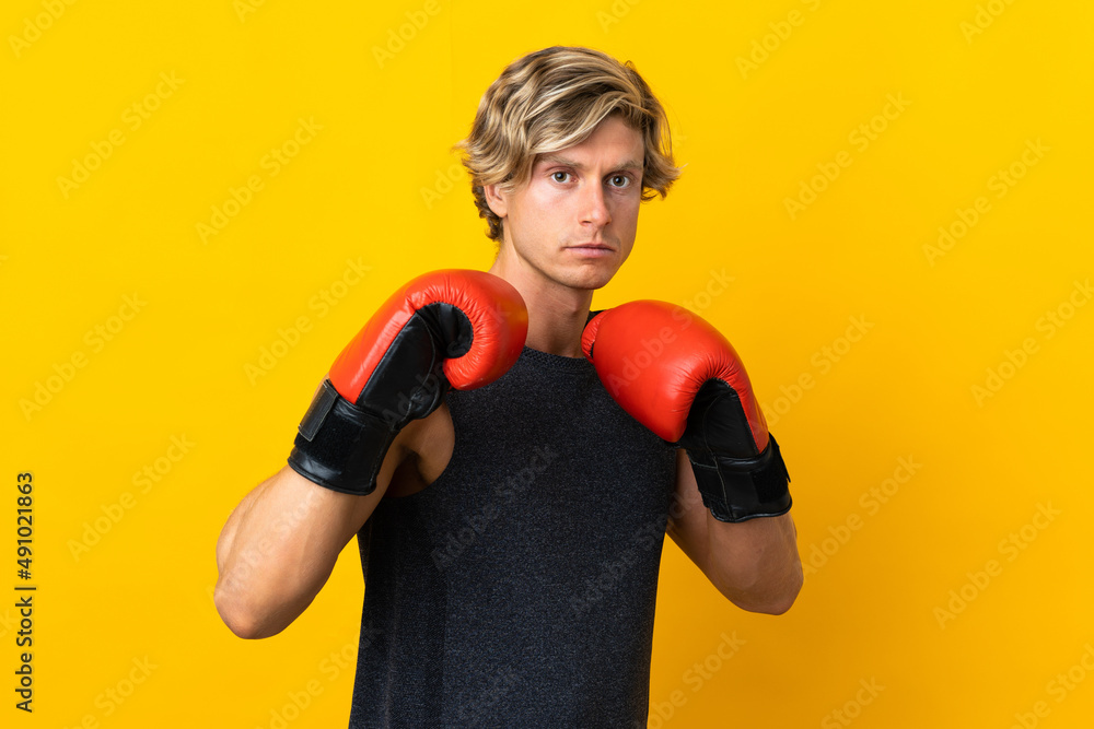 English man over isolated yellow background with boxing gloves English man over isolated yellow background with boxing gloves