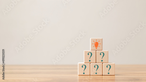 Creative concept. Think different, wooden cube with question mark and light bulb sign.
