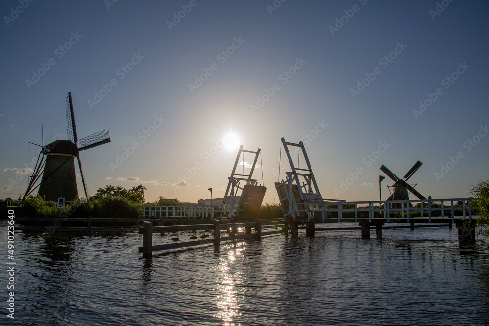 Windmills and wooden bridge by the water at Kinderdijk