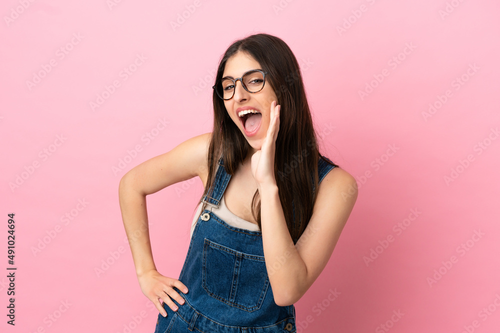 Young caucasian woman isolated on pink background shouting with mouth wide open Young caucasian woman isolated on pink background shouting with mouth wide open