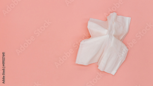 Top view flat lay cleansing wet wipes to remove makeup and clean the skin on orange background with copy space, White wet tissue paper healthcare and hygiene concept. © Kalyakan