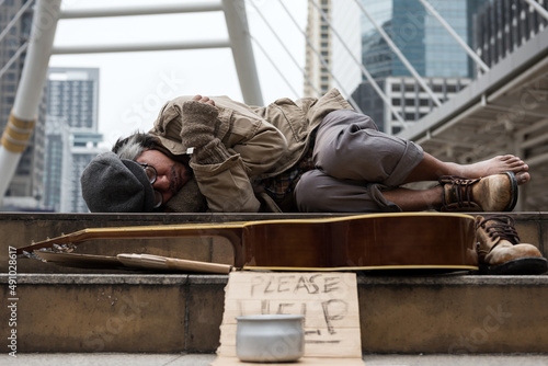 Old beggar or Homeless man sleep on city staircase