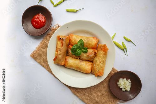 "Lumpia or lunpia, is traditional spring roll skin snack from Semarang, Indonesia. Traditional Spring rolls made  eggs, and chicken or shrimp,  stir-fried bamboo shoots.
isolated on white background"

