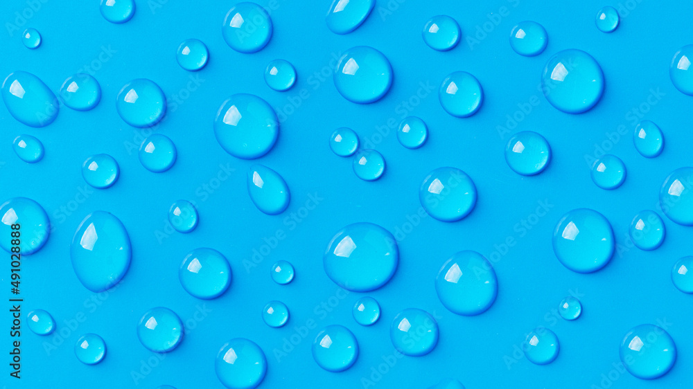 Water drops on blue background. Abstract drops of gel. Face serum cosmetics.