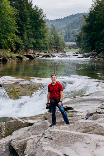 Man tourist visit river Prut and waterfall Probiy in Yaremche, Carpathians, Ukraine