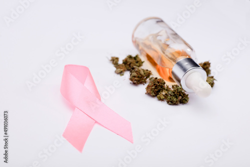 pink cancer ribbon with, oil bottlel with buds, white background ,Isolated background,