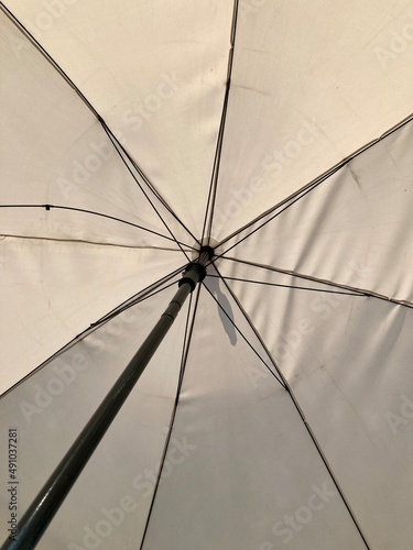 Close-up of an old grey umbrella  from the handle up